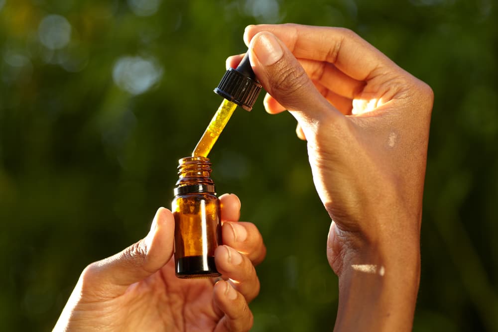 Woman holding hemp oil bottle